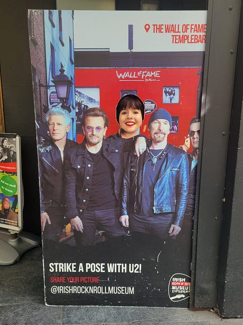 Five photos from the Irish Rock and Roll Museum and Temple Bar district. First, my daughter next to a photo of the band, U2. A display of three vintage guitars. The museum's Wall of Fame exterior and a streetscape in Temple Bar.