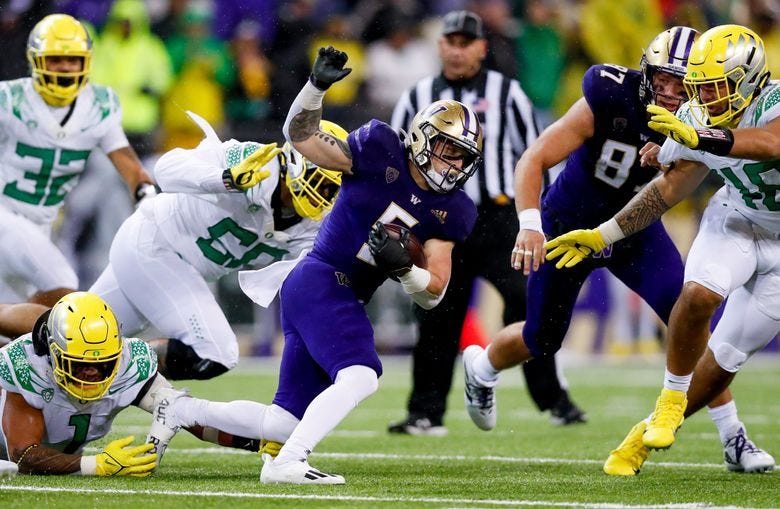 Washington Huskies running back Sean McGrew gets tripped up by Oregon Ducks linebacker Noah Sewell and goes down behind the line of scrimmage during the fourth quarter Saturday, Nov. 6, 2021, in Seattle. (Jennifer Buchanan / The Seattle Times)