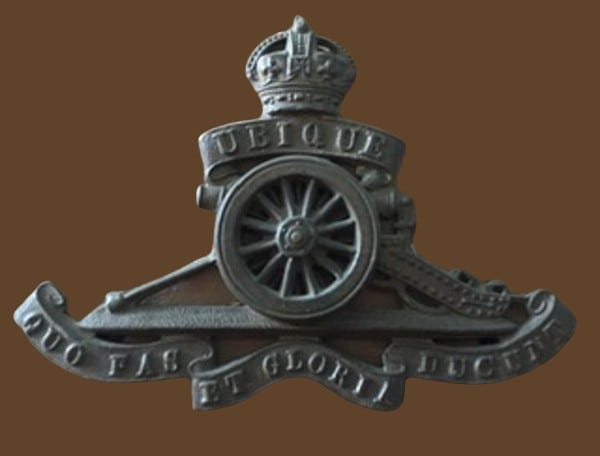 Image in metal of cannon/ artillery with a crown above it and latin wording on ribbon “Ubique Quo fas et gloria ducunt”