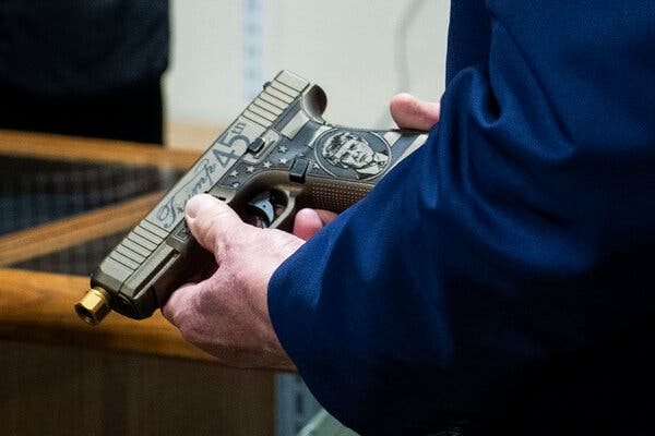 Mr. Trump holding the Glock, which shows his face in an oval on the grip and says “Trump 45th” on the barrel.