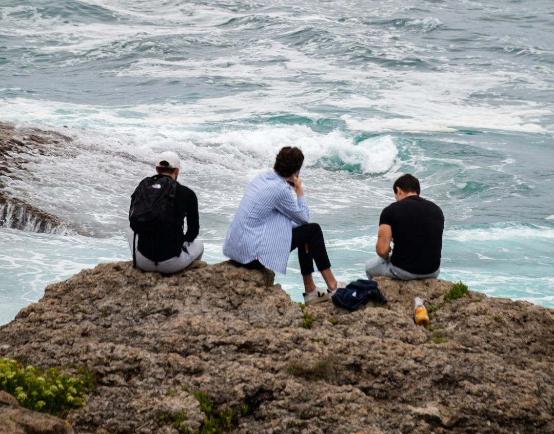 a group of people on a beach next to the ocean a group of people on a beach next to the ocean