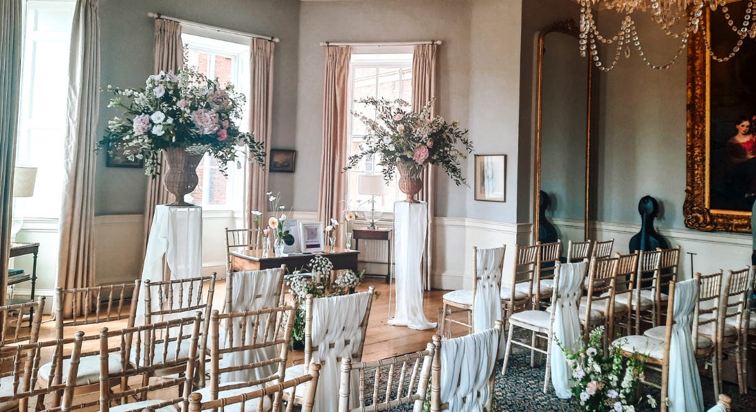 A wedding room with bouquets of flowers, seats, and gold curtains A wedding room with bouquets of flowers, seats, and gold curtains