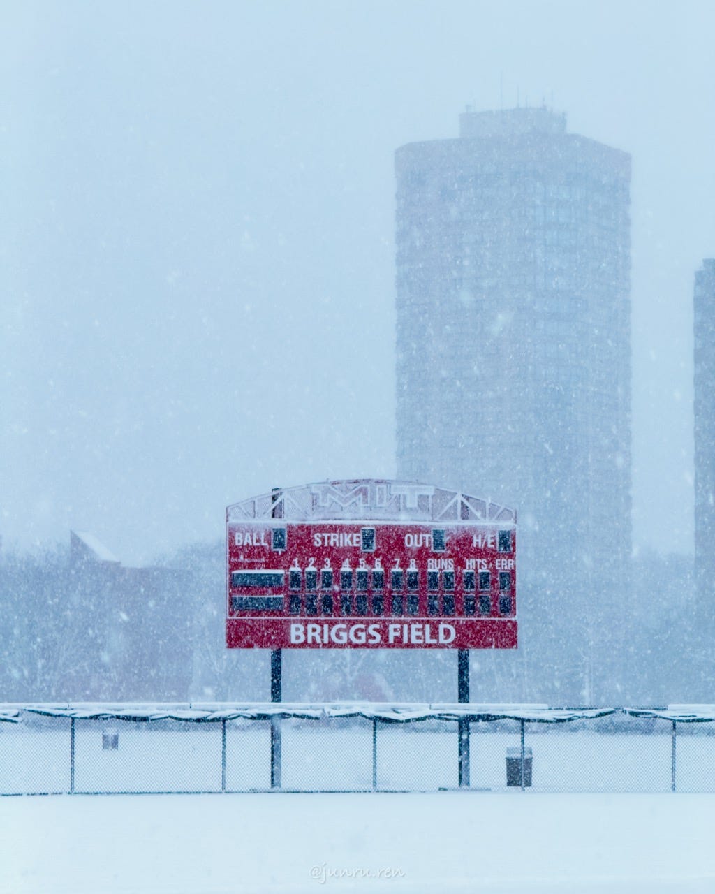MIT's red Briggs Field scoreboard seen through heavy snow, with campus towers fading into the background MIT's red Briggs Field scoreboard seen through heavy snow, with campus towers fading into the background