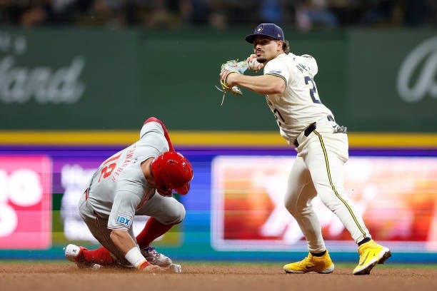 Willy Adames of the Milwaukee Brewers attempts to turn a double play as Kyle Schwarber of the Philadelphia Phillies slides into second base during...