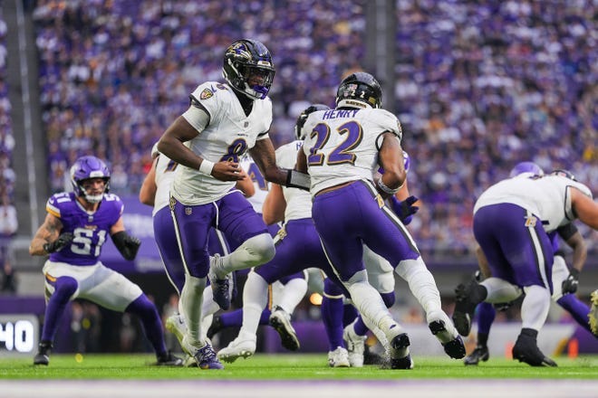 Nov 9, 2025; Minneapolis, Minnesota, USA; Baltimore Ravens quarterback Lamar Jackson (8) hands the ball off to running back Derrick Henry (22) against the Minnesota Vikings in the third quarter at U.S. Bank Stadium.