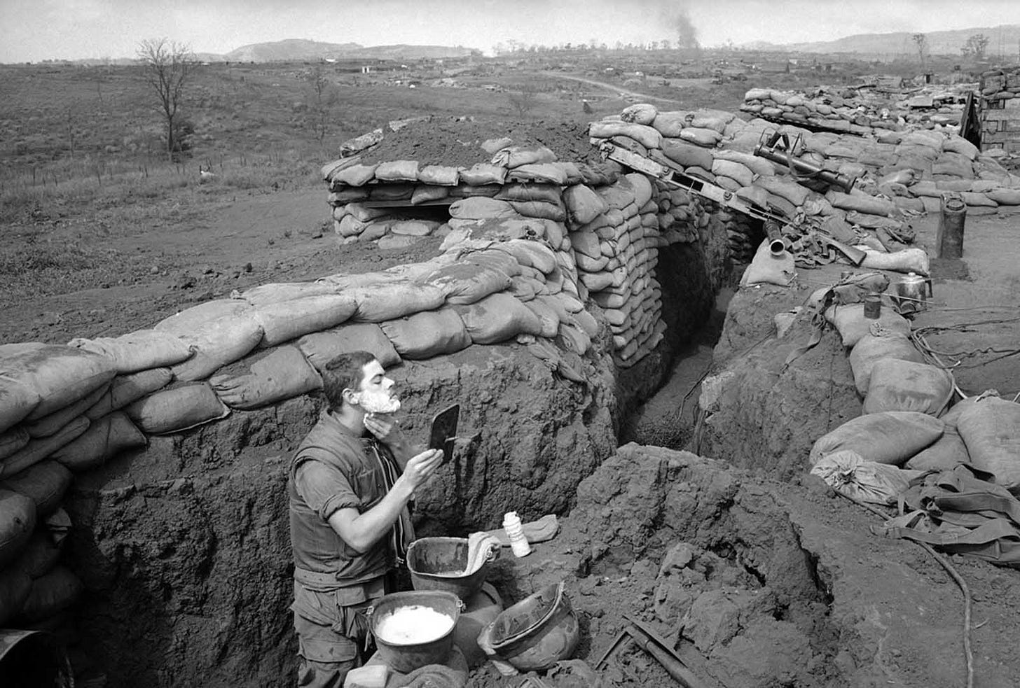 March 5, 1968, Khe Sanh Base: Marine Lance Corporal Roland Ball shaves in a trench, using a helmet and a vehicle mirror, amidst the North Vietnamese siege, a glimpse into daily life during wartime. March 5, 1968, Khe Sanh Base: Marine Lance Corporal Roland Ball shaves in a trench, using a helmet and a vehicle mirror, amidst the North Vietnamese siege, a glimpse into daily life during wartime.