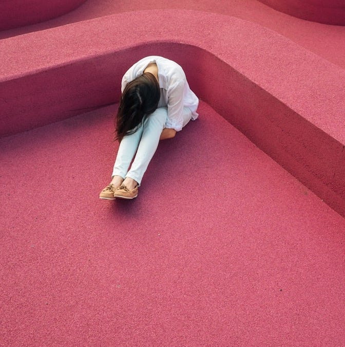 woman sitting leaning forehead on knee