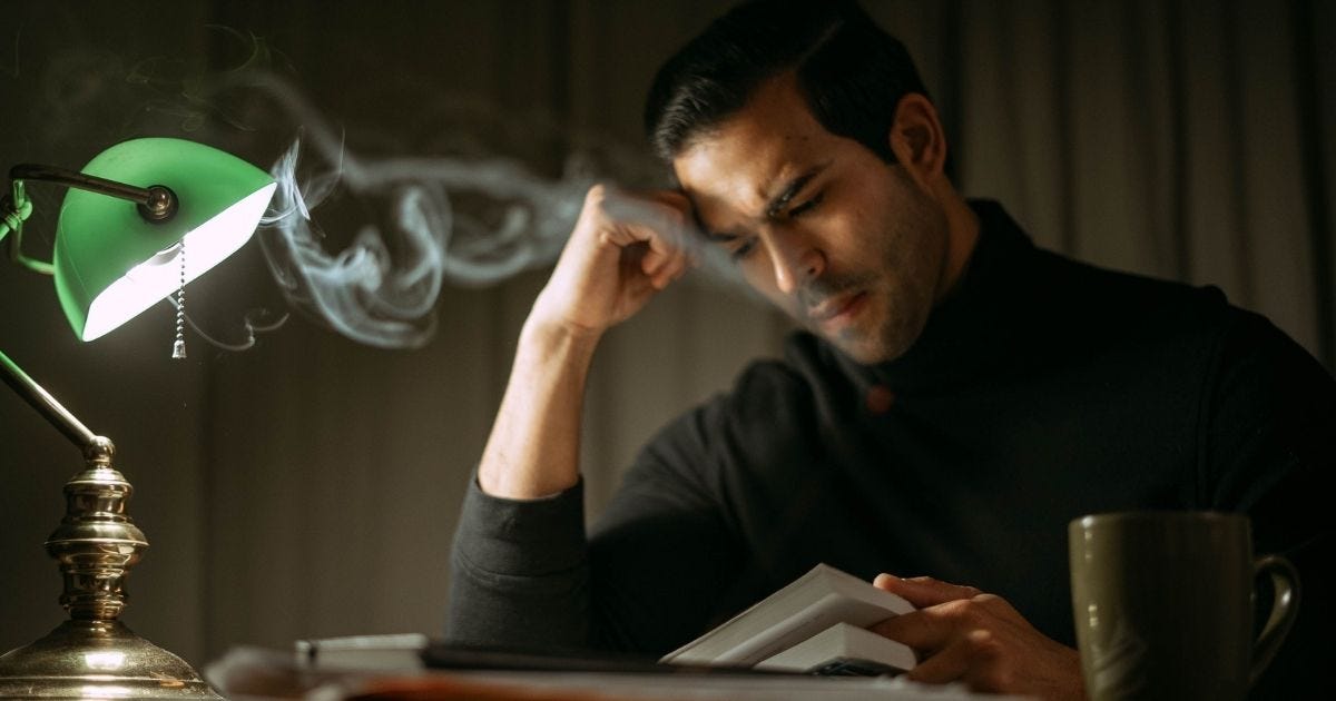 Thoughtful man reading a book in a dimly lit office, creating a vintage workspace vibe Thoughtful man reading a book in a dimly lit office, creating a vintage workspace vibe