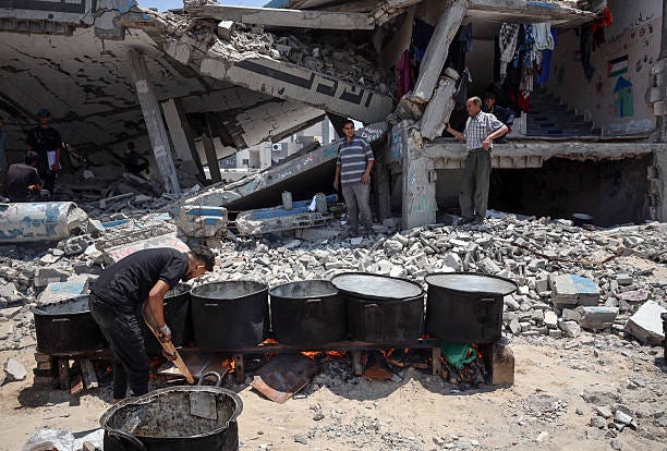 Palestinian children wait with others for food at a distribution point in Gaza City, on June 3, 2025. Israel faces growing condemnation over the...