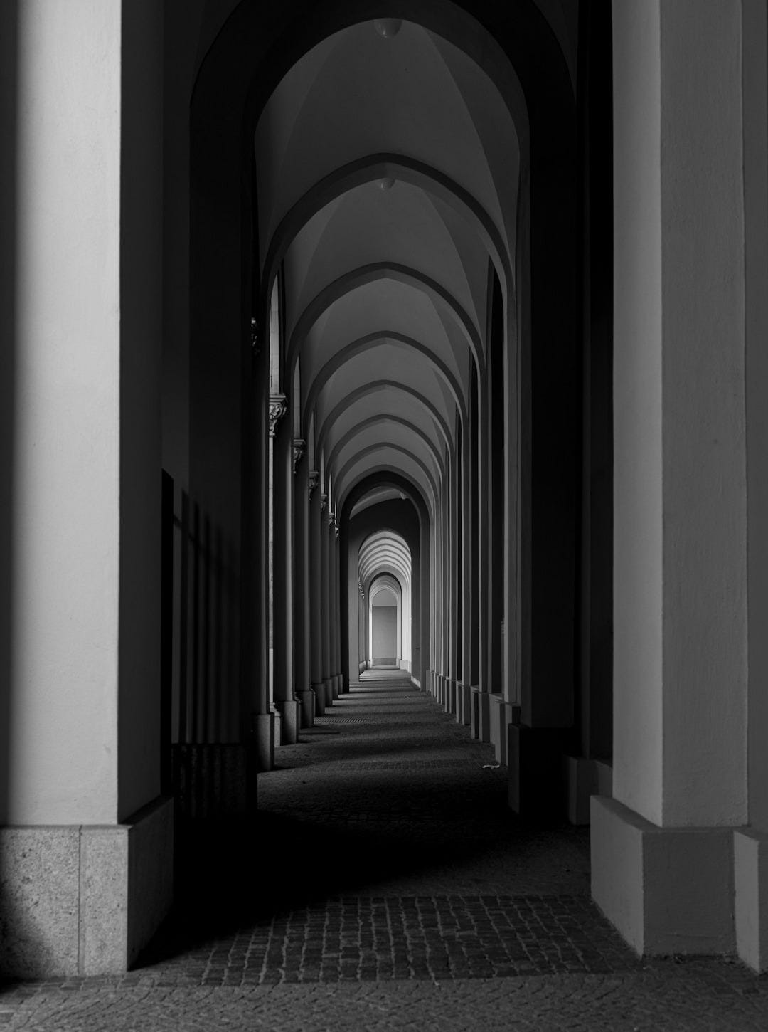 grayscale photo of hallway with columns