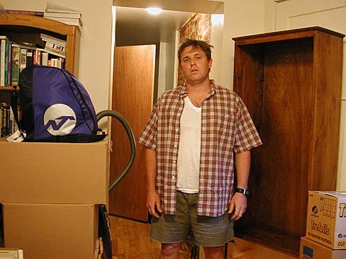 Derek Olson stands among some of the boxes he'd hoped to unpack last week.