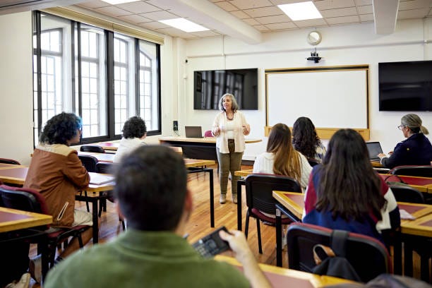 Mature university instructor and students in classroom