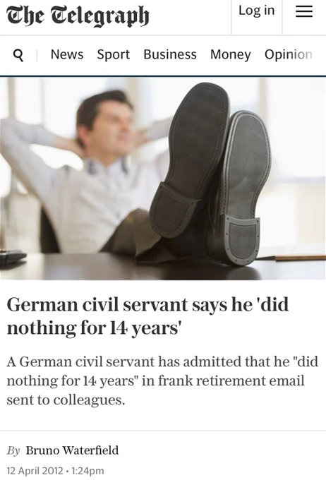 A man sitting in an office chair with his feet propped up on a desk, wearing dress shoes and a white shirt. The desk has papers and a pen visible. The text overlay reads "The Telegraph" at the top, with navigation tabs for "News, Sport, Business, Money, Opinion," and a headline "German civil servant says he \'did nothing for 14 years\'" by Bruno Waterfield, dated 12 April 2012, 1:24pm.