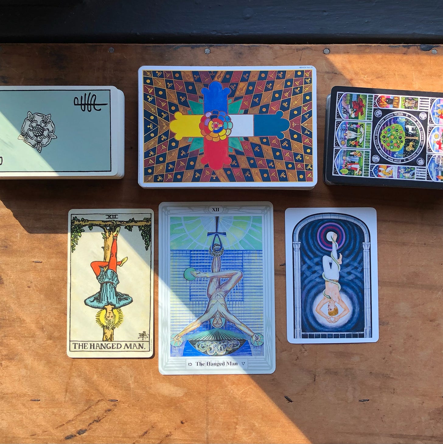 The Hanged Man from Rider-Waite Smith Tarot, Thoth Tarot, and Jungian Tarot.