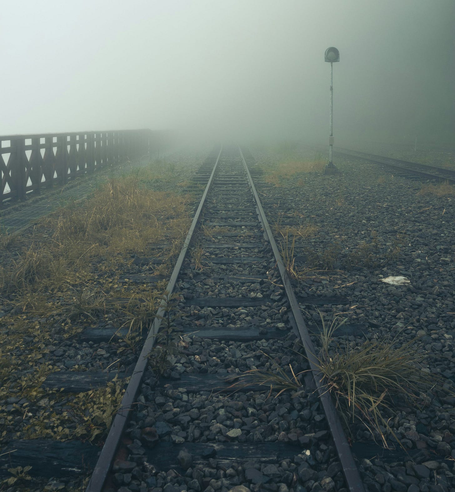 a train track in the middle of a foggy field a train track in the middle of a foggy field