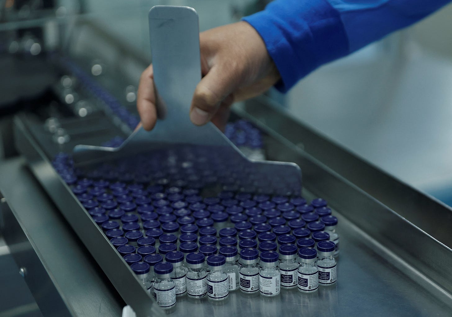 An employee collects vials of the R21 malaria vaccine afer they are labelled inside a lab at the Serum Institute of India, Pune