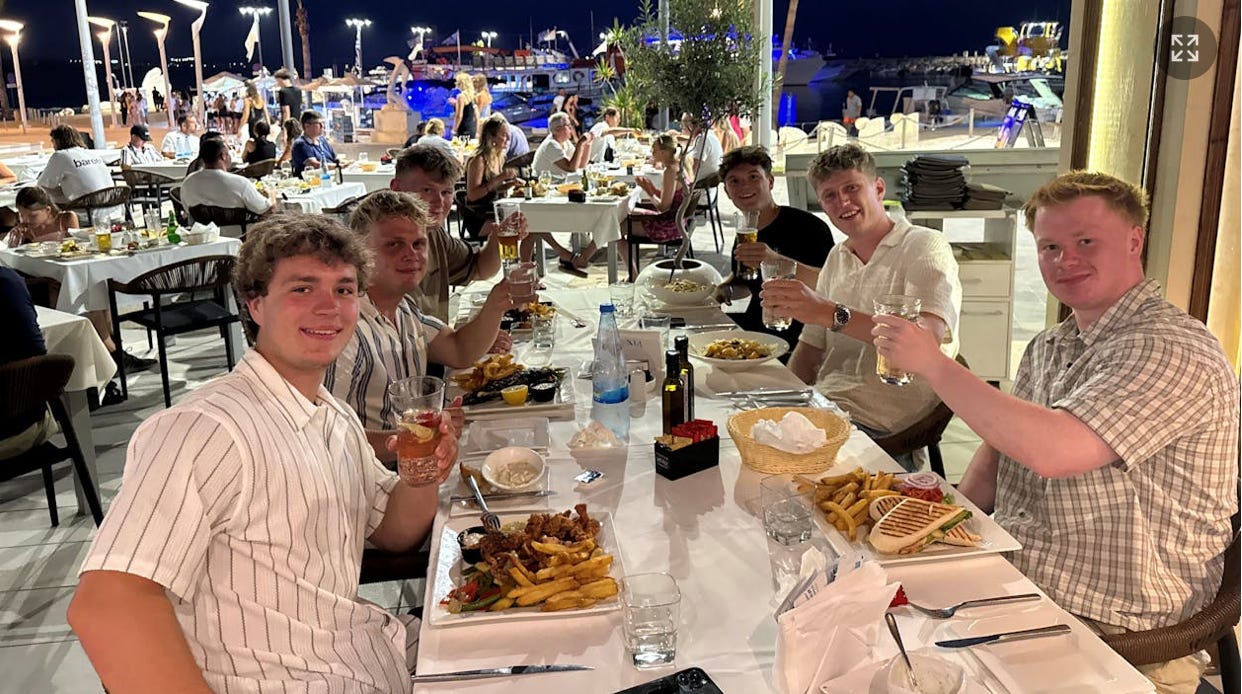 A group of people sitting at a table with food and drinks

AI-generated content may be incorrect.