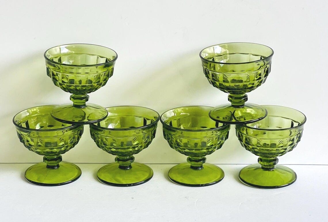 May include: Seven green glass dessert or champagne glasses are displayed. Each glass has a textured bowl and a short stem. The glasses are arranged in a pyramid shape. The glasses are suitable for serving desserts or champagne. May include: Seven green glass dessert or champagne glasses are displayed. Each glass has a textured bowl and a short stem. The glasses are arranged in a pyramid shape. The glasses are suitable for serving desserts or champagne.
