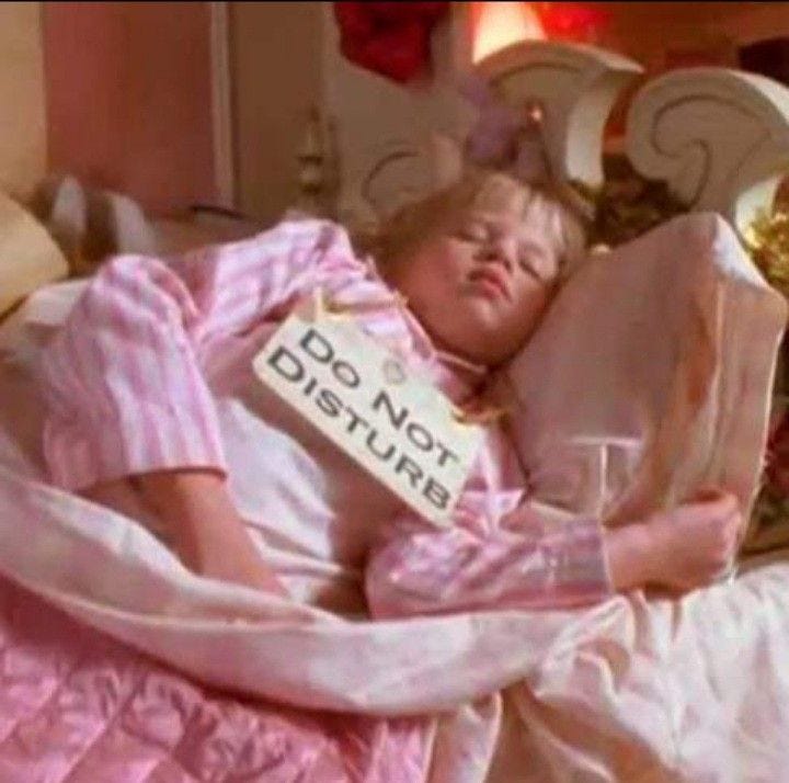 This may contain: a woman laying in bed with a don't disturb sign on her arm and holding a glass This may contain: a woman laying in bed with a don't disturb sign on her arm and holding a glass