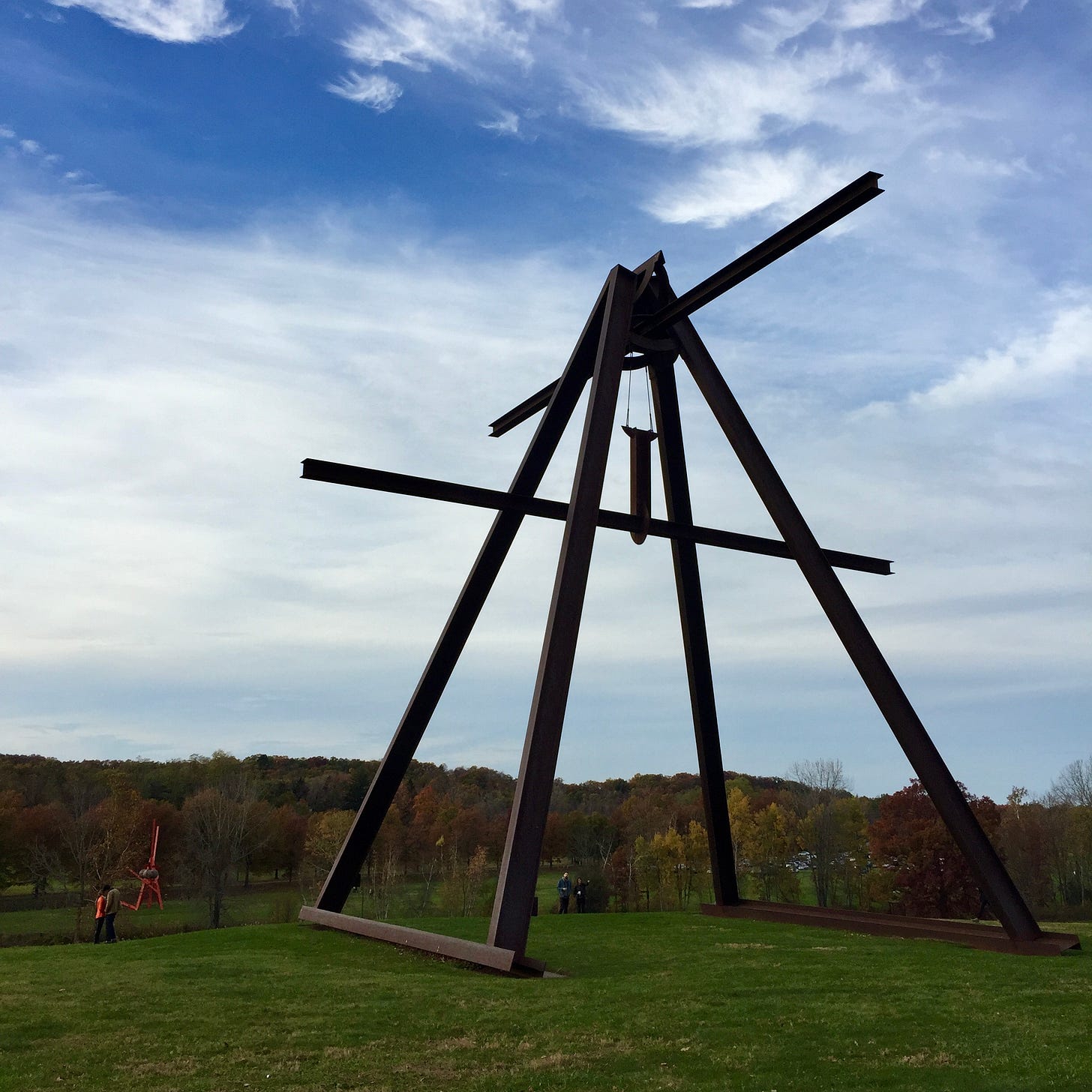 A huge triangular metal sculpture stands tall against a blue sky