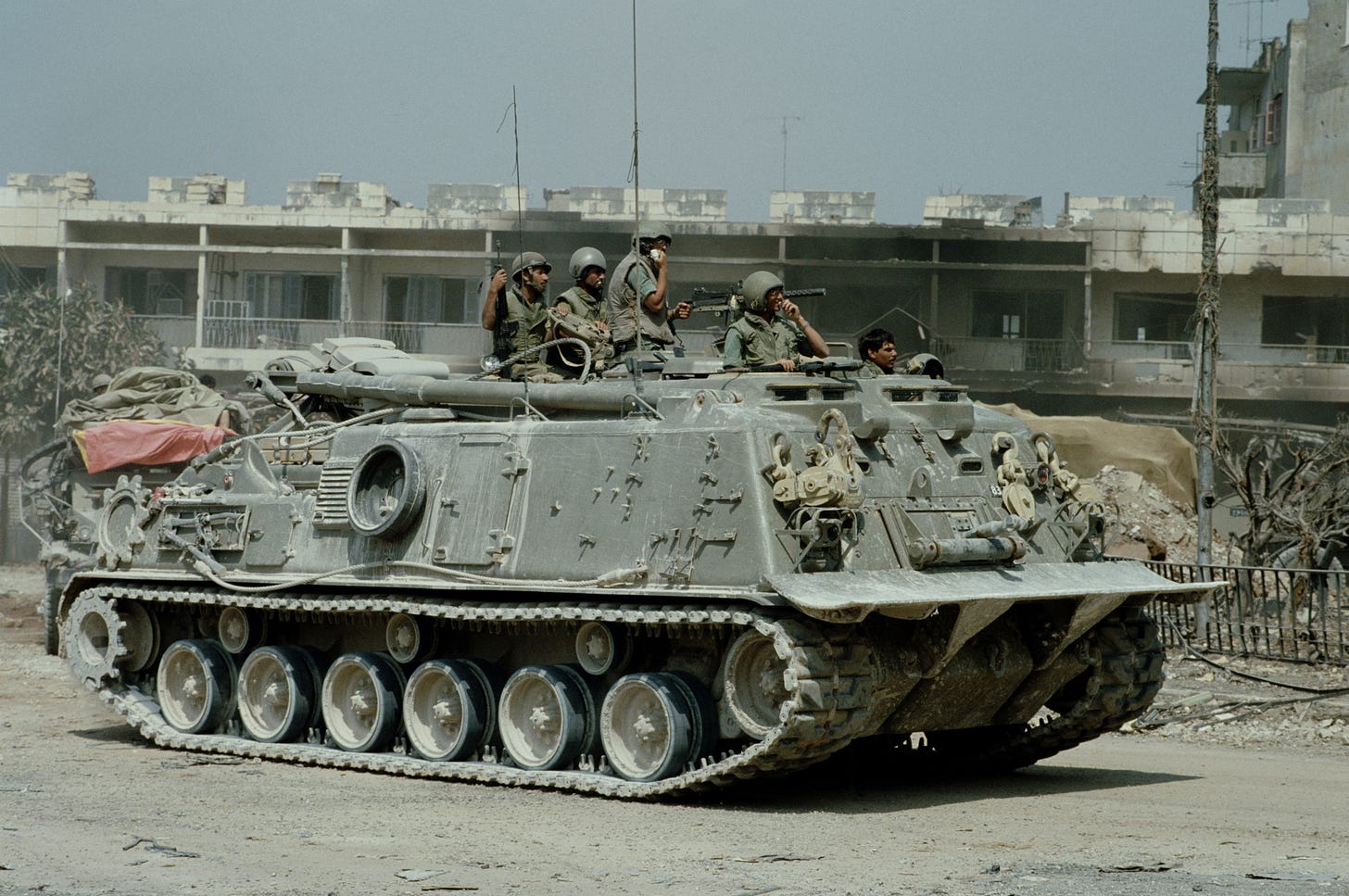 Israeli soldiers pass destroyed houses on the streets of the Lebanese port city of Sidon during the Israeli army invasion in June 1982. Photo by Bryn Colton/Getty Images