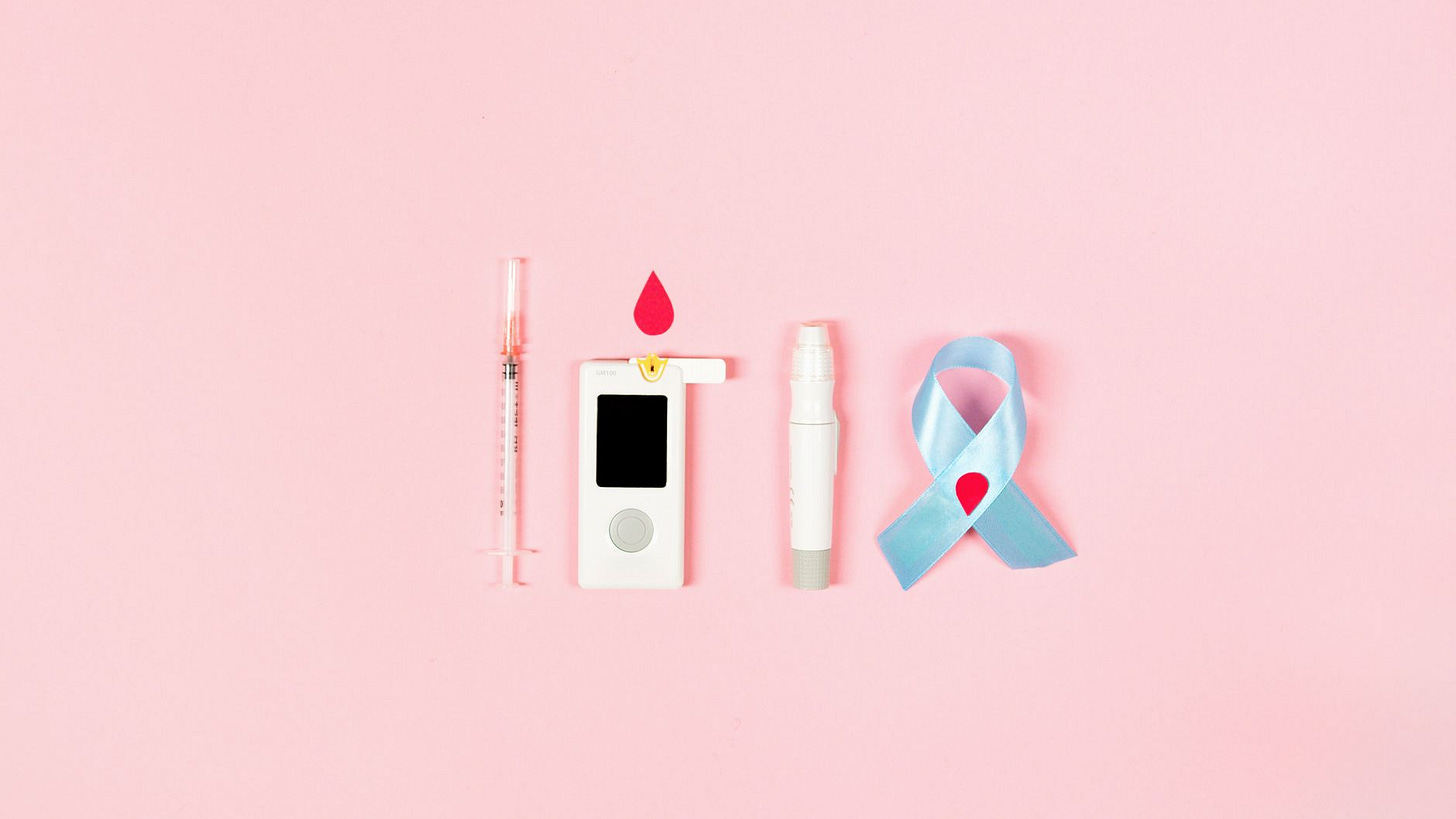 Photo by Artem Podrez on Pexels Glucometer, syringe, lancet pen, and ribbon symbolizing diabetes awareness on pink background. (stock photo)