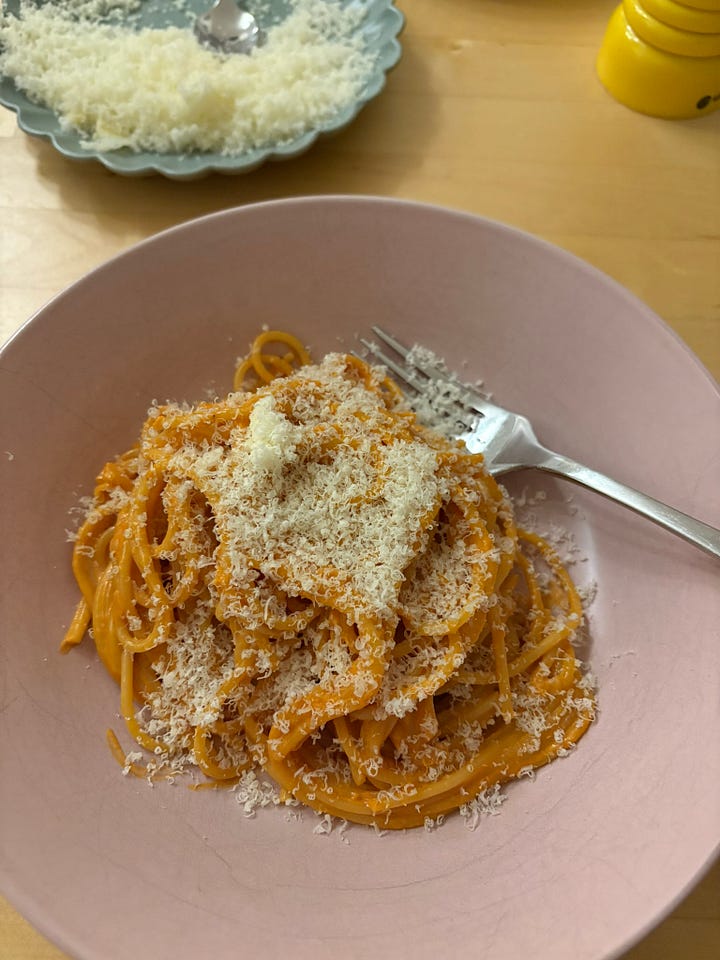 Bowl of preserved lemon pasta topped with cheese. A plate of cabbage parm