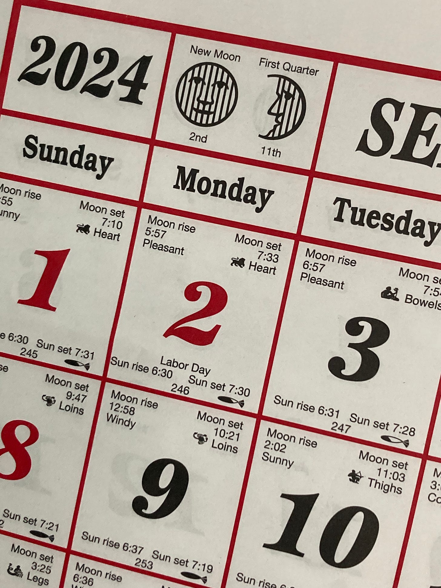 photograph of an almanac calendar black text, red numbers and borders, white background