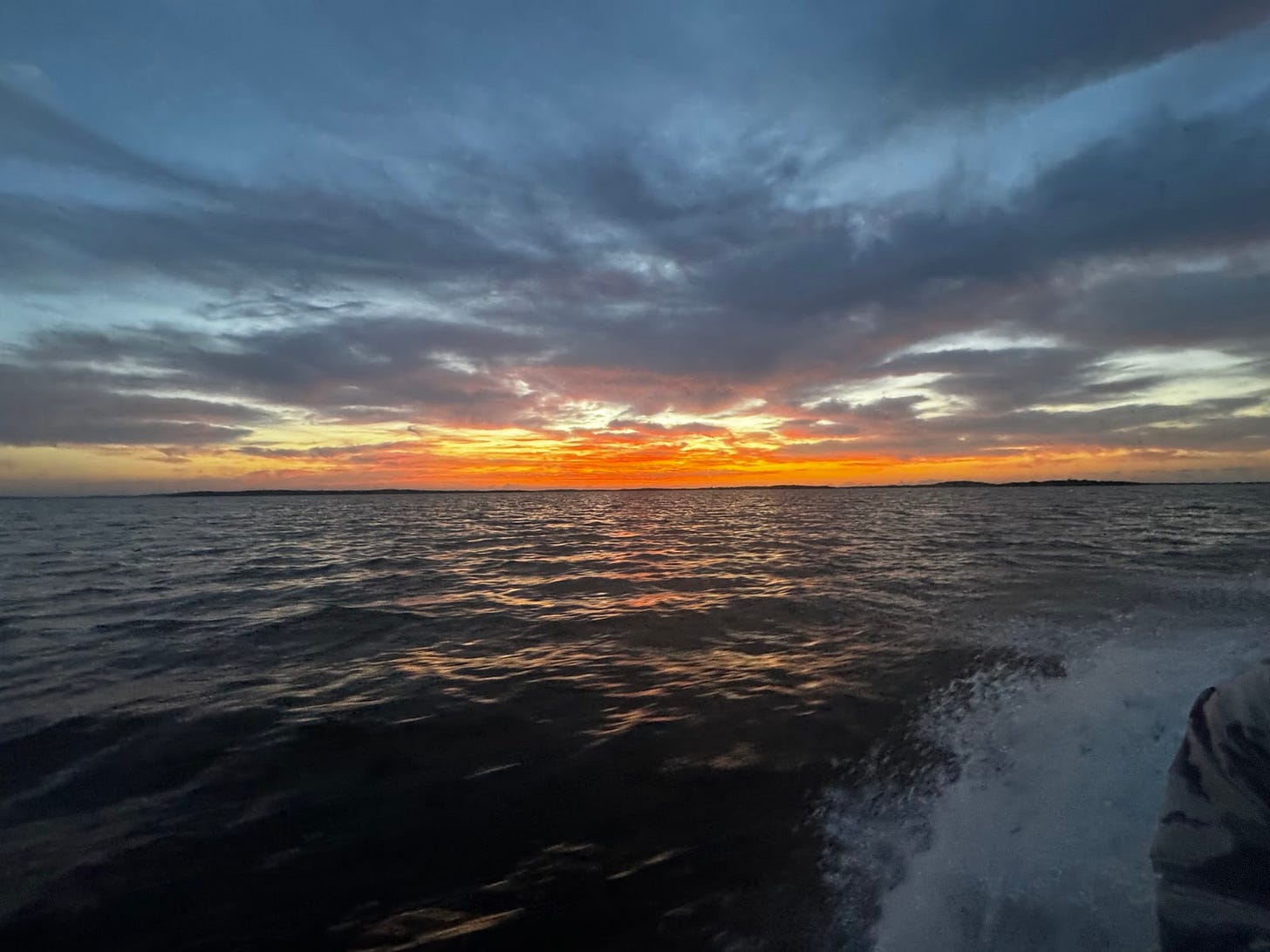 A breathtaking sunset spreads vibrant colors across the sky and water, symbolizing the quiet reflection and gratitude found at the close of a challenging day on the Everglades.