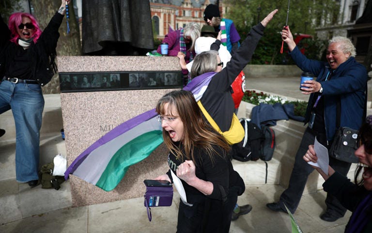 Gender-critical campaigners celebrate after the Supreme Court ruling - HENRY NICHOLLS / AFP