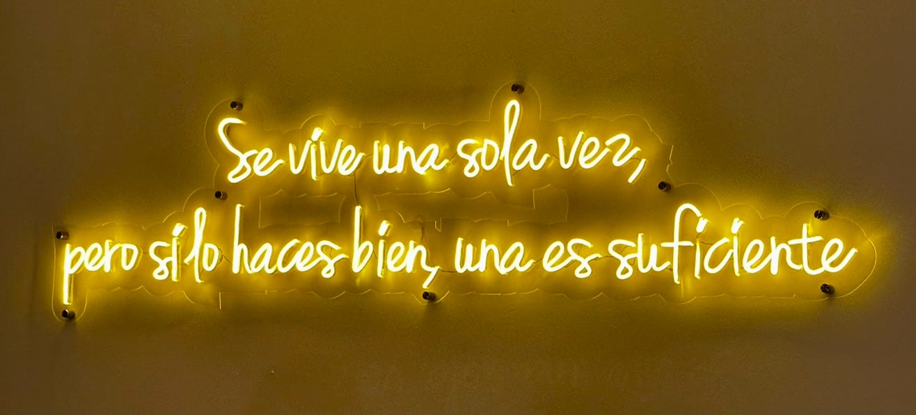 A neon sign with white text

Description automatically generated