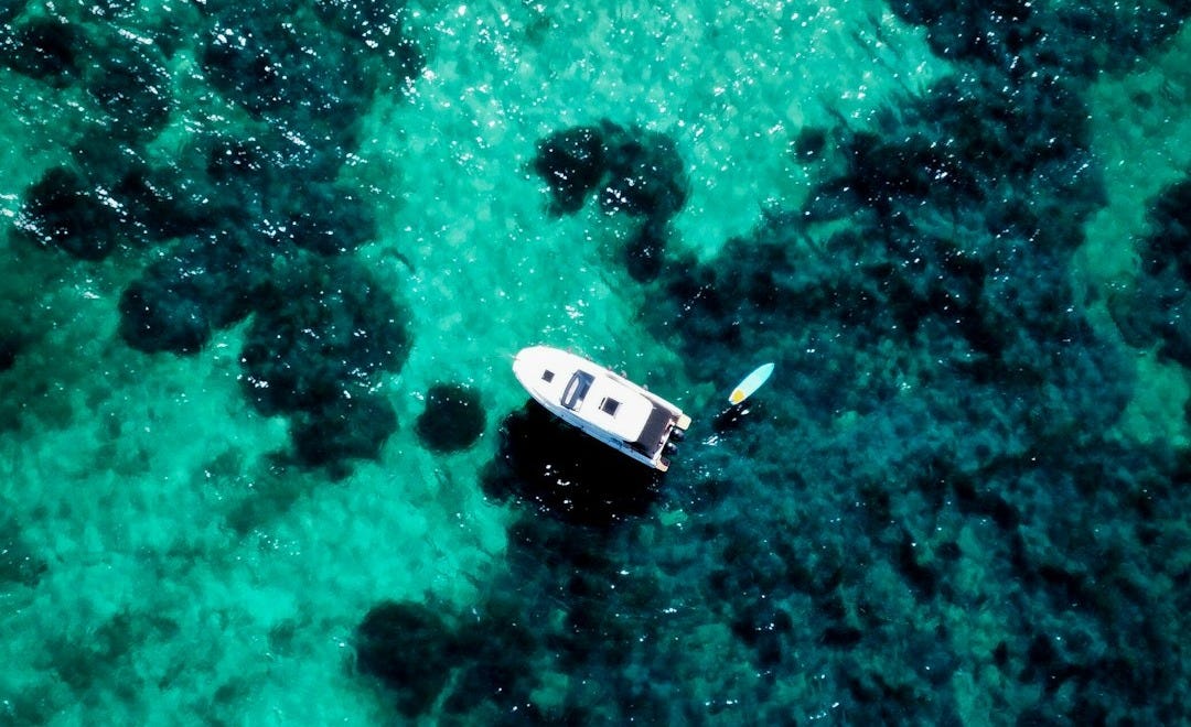 two small boats floating on top of a body of water two small boats floating on top of a body of water