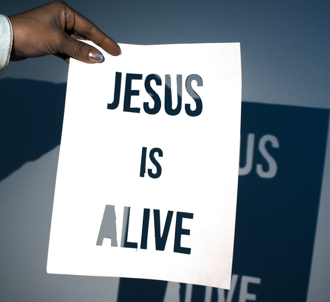 a person holding a piece of paper with the words jesus is alive on it a person holding a piece of paper with the words jesus is alive on it