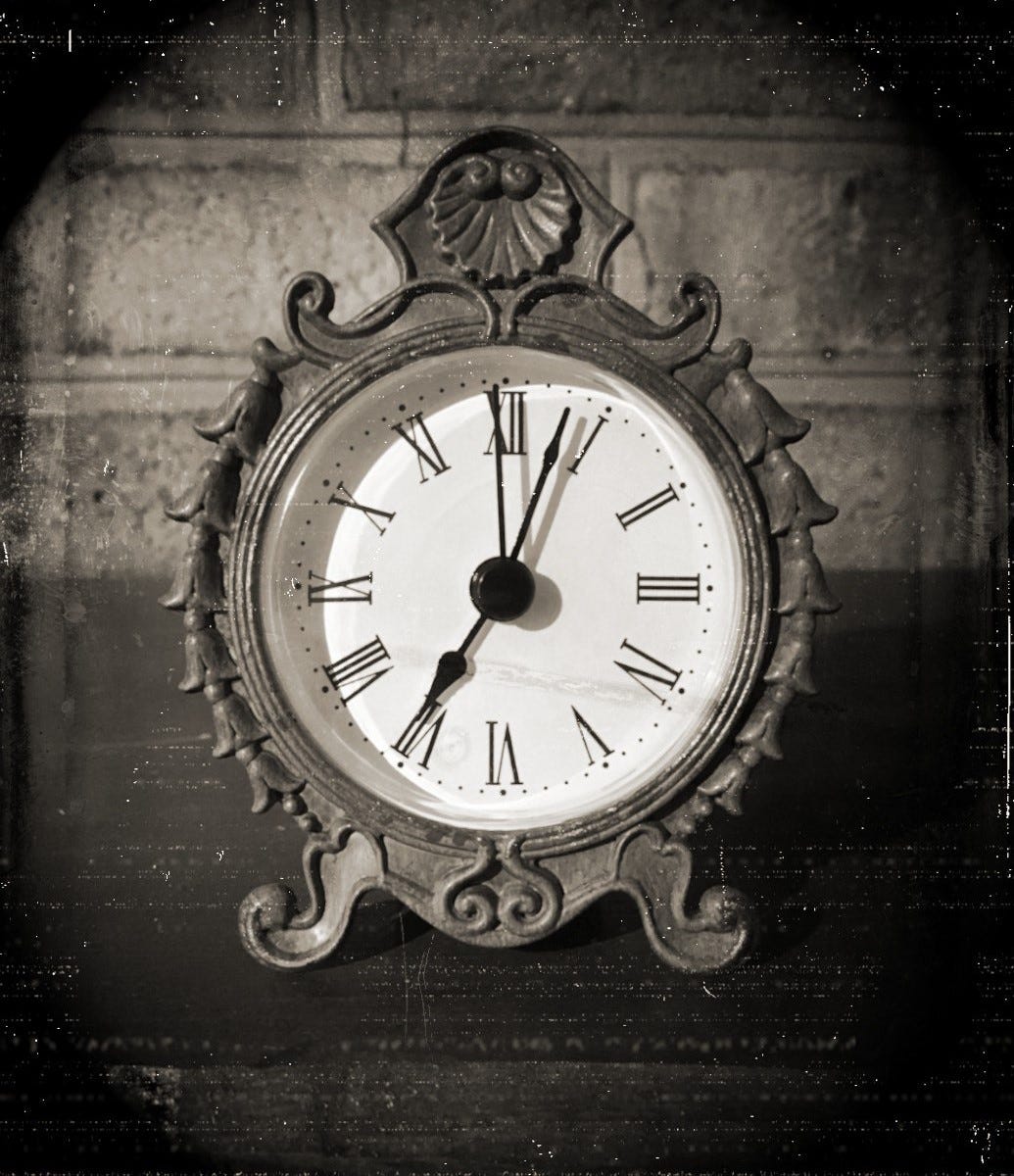 A sepia-toned photo made to look like a Victorian era daguerreotype. The photo shows an antique-looking clock against a brick background.