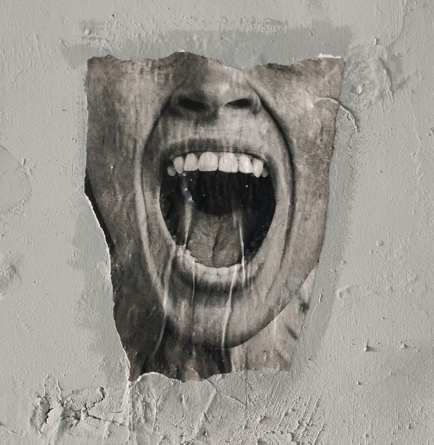 A ripped poster of a woman's mouth screaming, glued to a white wall.
