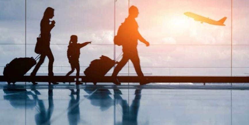A person and a child walking with luggage

Description automatically generated