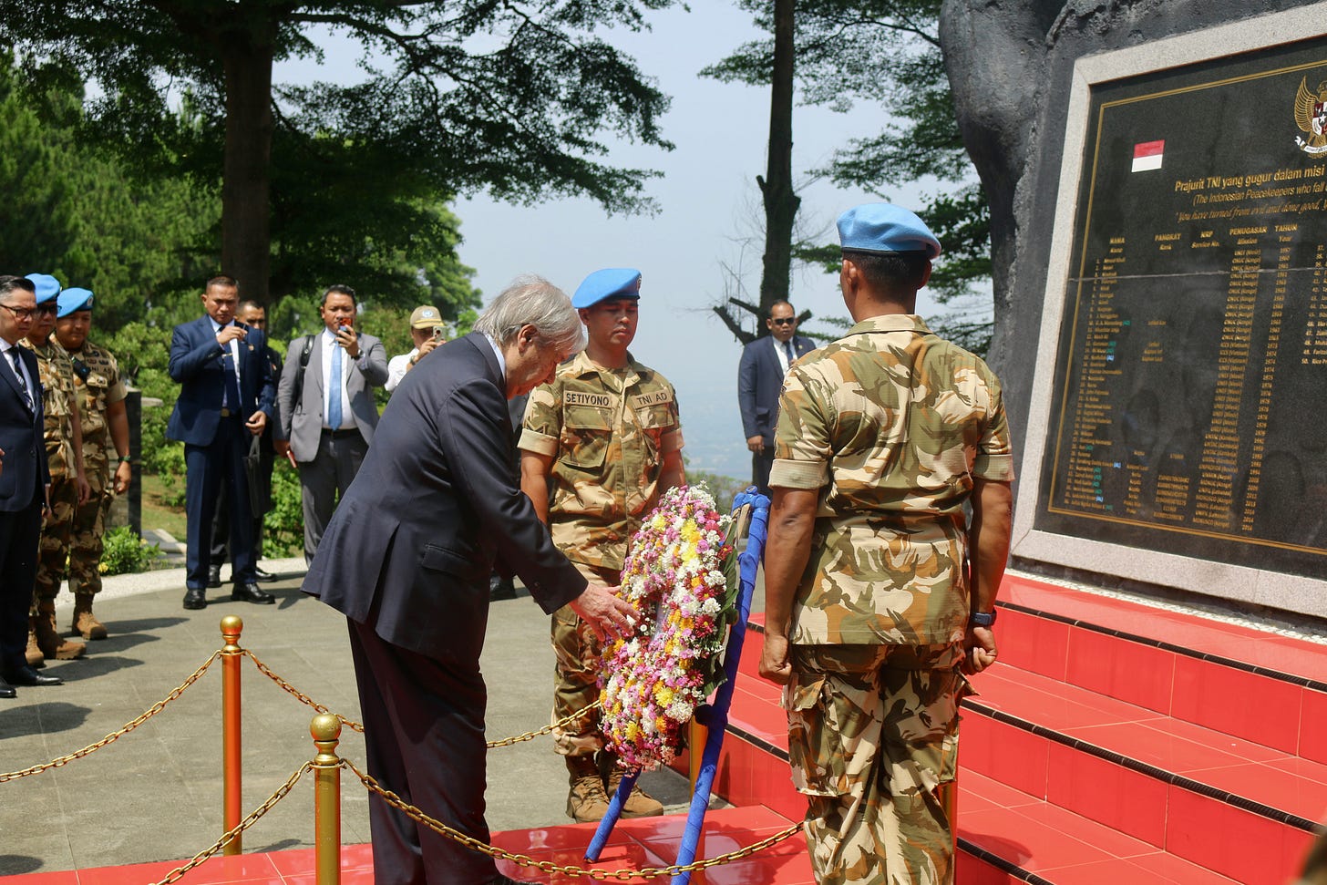 Three men stand in front of a monument honouring Indonesian peacekeepers. UN Secretary-General António Guterres stands in the centre, accompanied by two Indonesian peacekeepers, one on each side. Guterres lays a wreath on Monday (19 October) in Sentul, West Java, to honour Indonesian peacekeepers who lost their lives while serving on UN peacekeeping missions to maintain peace and stability in conflict-affected regions.
