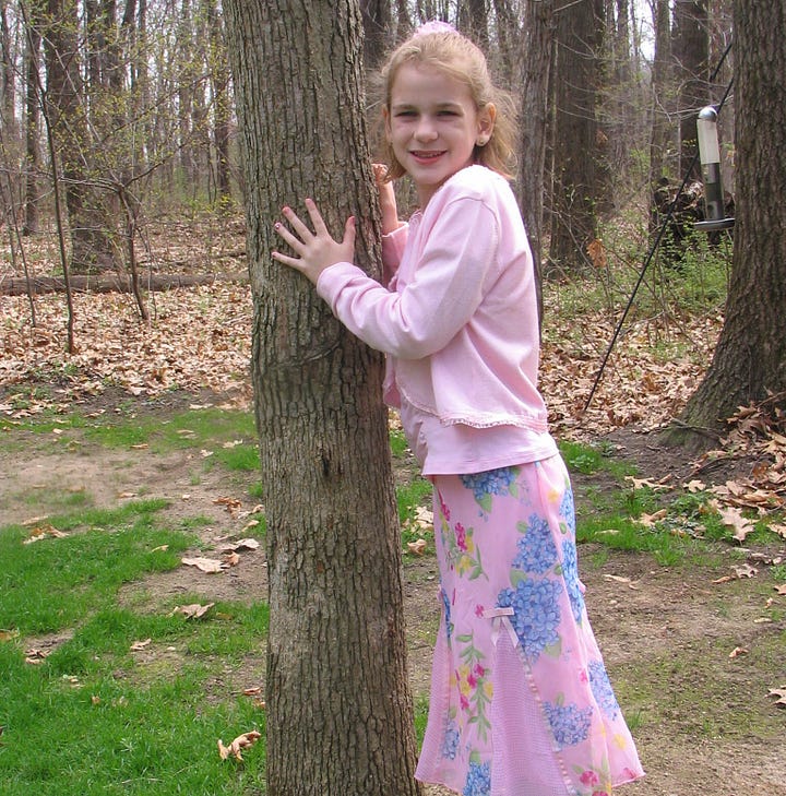 Two little girls squinting into the sun, a young boy with goofy smile, four children dressed up with silly expressions on faces, and young girl in Sunday best hugging a tree.
