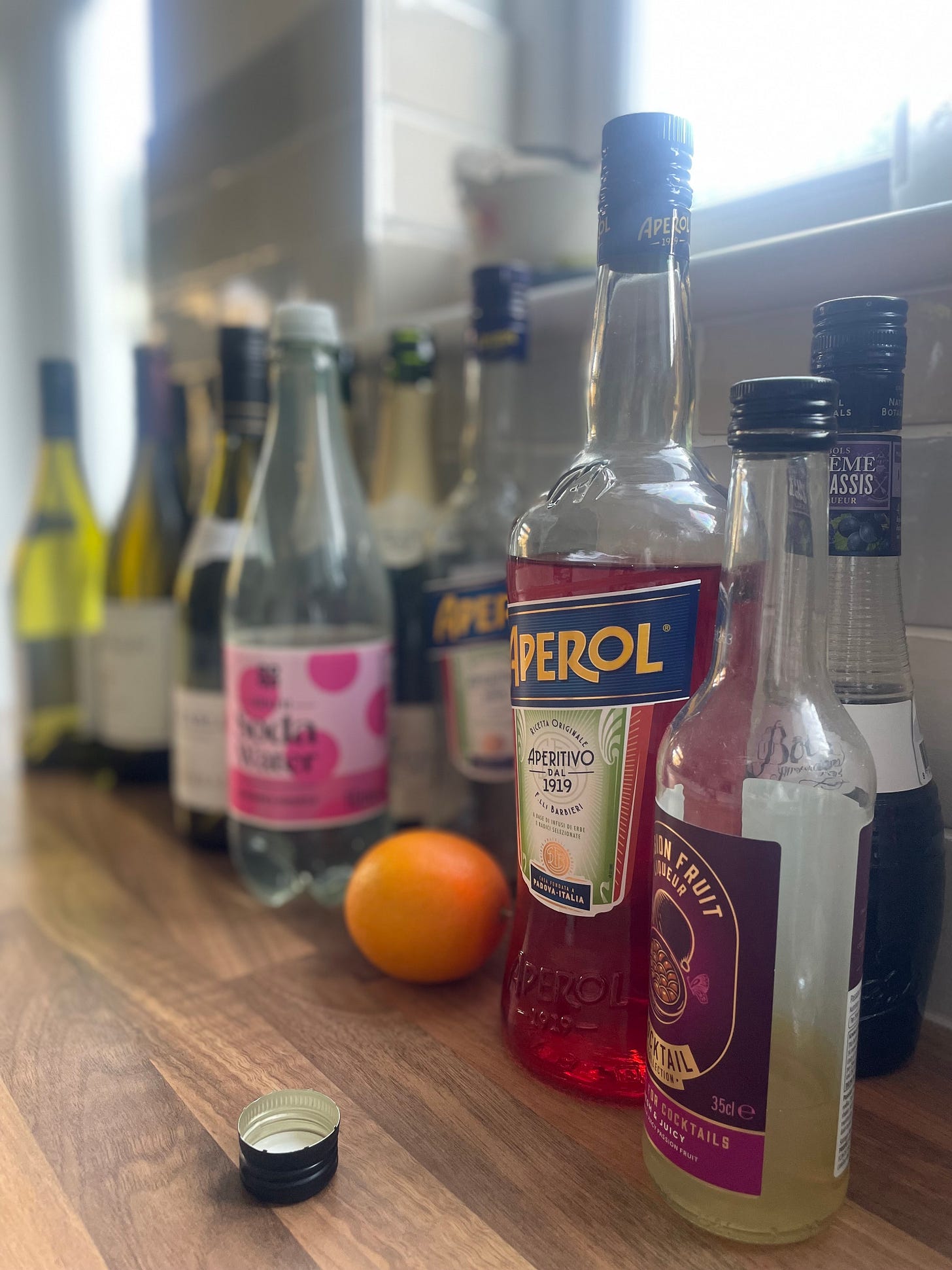 A blurry row of empty wine and other alcohol bottles