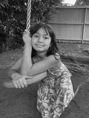 black-and-white photo of girl holding on to swing seat in garden
