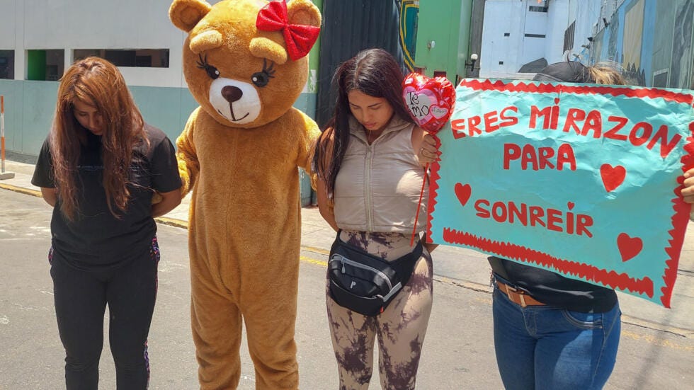 El policía disfrazado de oso posa junto a las detenidas en la operación contra el tráfico de drogas el 14 de febrero de 2024 en Lima