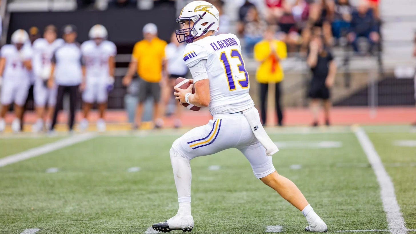 Taylor Elgersma holds the football with two hands while looking downfield to pass the ball during a Wilfrid Laurier University Golden Hawks football game Taylor Elgersma holds the football with two hands while looking downfield to pass the ball during a Wilfrid Laurier University Golden Hawks football game