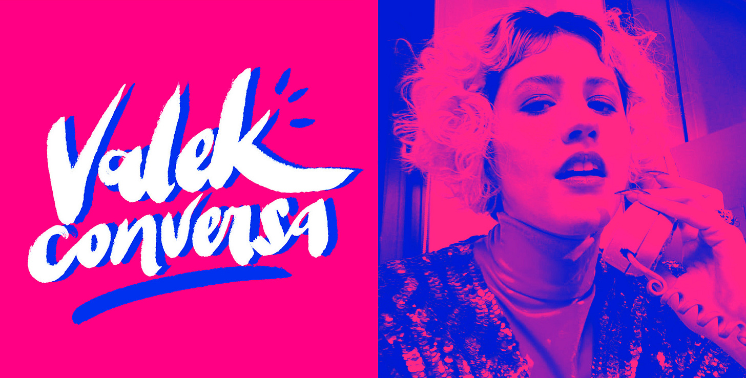Capa do podcast Valek Conversa: à esquerda o nome do programa, em caligrafia branca e grossa, sombra azul sobre fundo rosa. À direita, foto da entrevista nas mesmas cores do programa. É uma mulher de cabelo curto e claro ondulado, atendendo um telefone com unhas longas e coloridas. Ela usa um casaco de paetê sobre uma blusa de gola longa