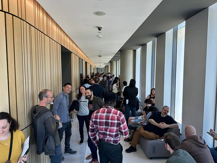 Outside the hearing room, creatives gather and wait for public comments