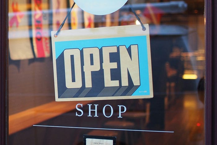 An ‘open for business’ sign on the front of a retail shop. Retail workers are often the target of customer abuse, and it isn’t acceptable.