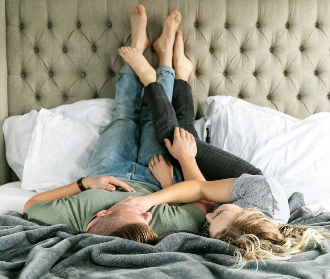 woman in blue denim jeans lying on bed