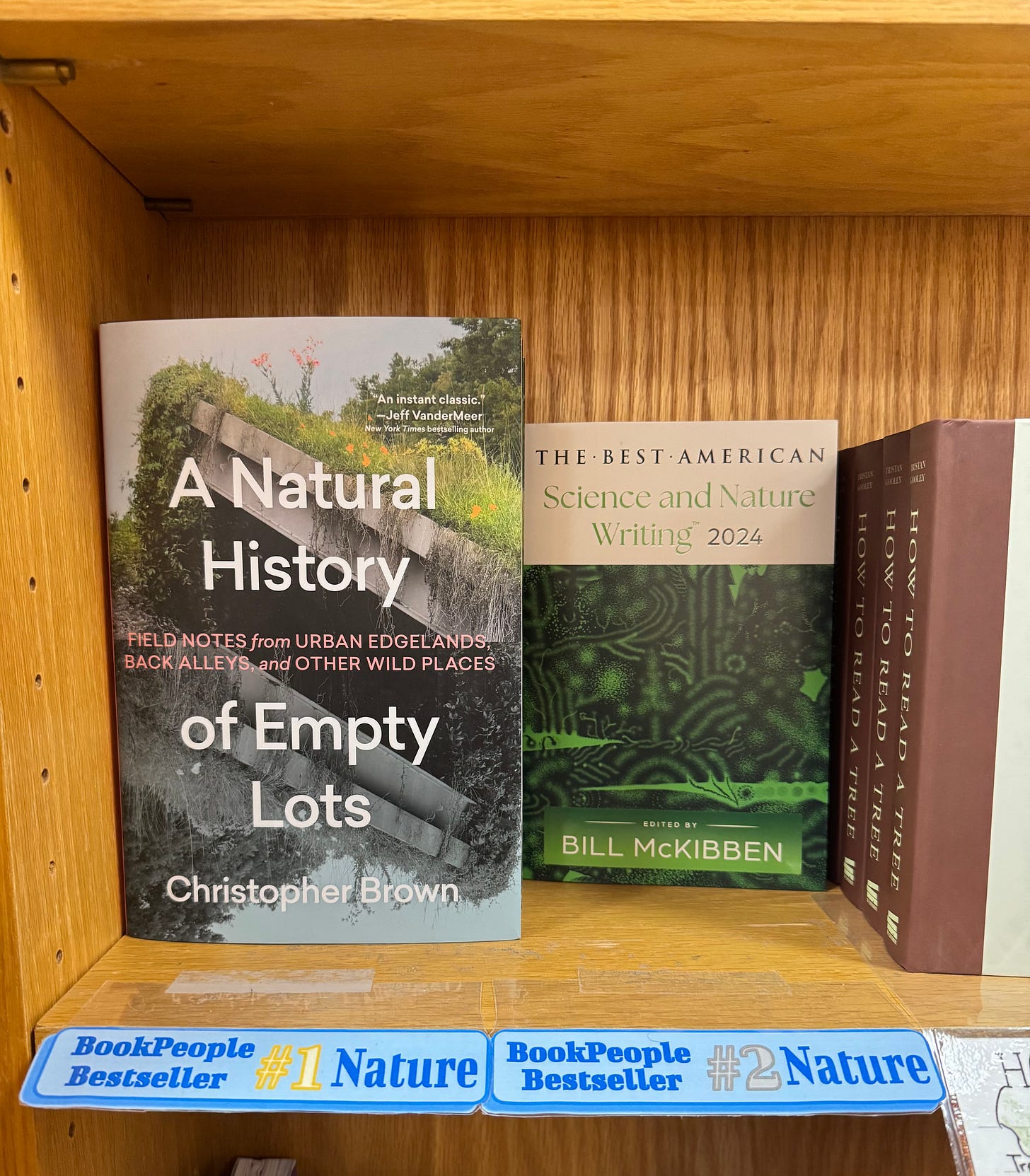 BookPeople bookshelf showing A Natural History of Empty Lots as #1 Bestseller in Nature and Best American Science and Nature Writing 2024 (Bill McKibben ed.) as #2