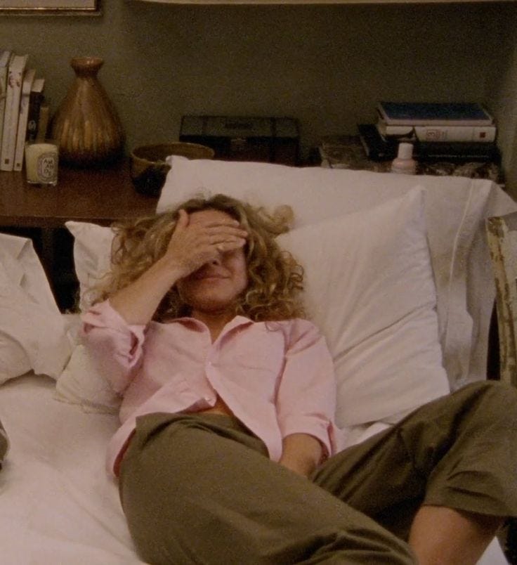 This may contain: a woman laying in bed covering her eyes This may contain: a woman laying in bed covering her eyes