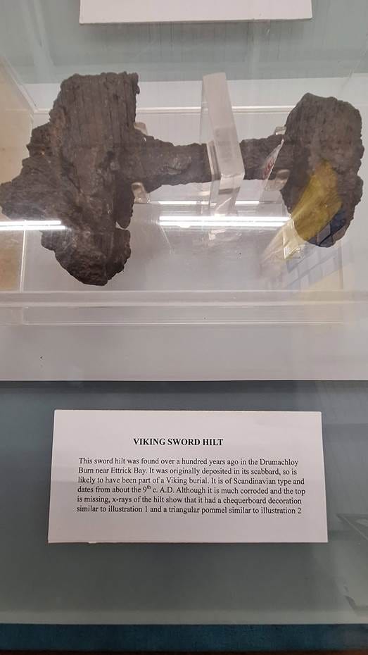 May be an image of text that says "VIKING SWORD VIKINGSWORDHILT HILT This sword ilt was was found vera hundredyears years ago theDrumachloy ne Ettrick Bay.I oripinally deposite ositedir scabbard, sois is wiiaiiss gburial. ofa ype dates ahoutth Nthougl itisn much dthe τορ is missing, x-rays ofthe hithohtihamahmebe iltshow thati had chequerboard decoration similar illustration and triangulur pommel similar to illustration2 2"