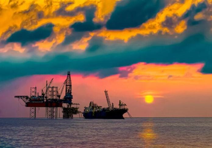 A group of oil rigs in the water during sunset Description automatically generated with low confidence A group of oil rigs in the water during sunset Description automatically generated with low confidence
